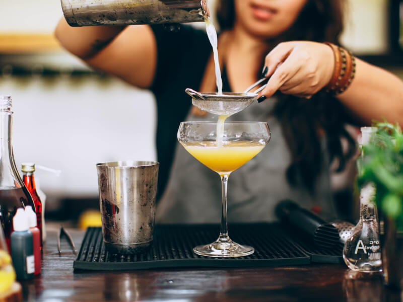 A closeup of hands pouring a DIY cocktail